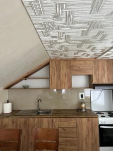 a kitchen with wooden cabinets and a coffered ceiling at Domaćinstvo Kondić in Podovi +14 photos