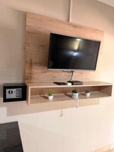 a flat screen tv sitting on a wooden shelf at On Smook in Zeerust