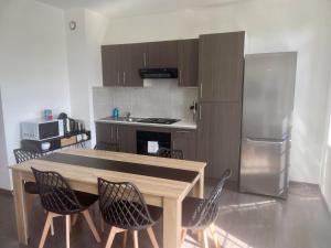 a kitchen with a table and chairs and a refrigerator at Business Apparts Caudry in Caudry