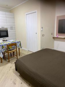 a bedroom with a bed and a table and a television at Mono perfetto per Ospedale e Treni Check-in rapido in Livorno
