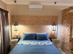 a bedroom with a blue bed with two night stands at On Smook in Zeerust