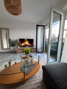 a living room with a table and a fireplace at DaxLodge T2 Sotf in Dax