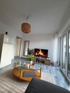 a living room with a table and a fireplace at DaxLodge T2 Sotf in Dax