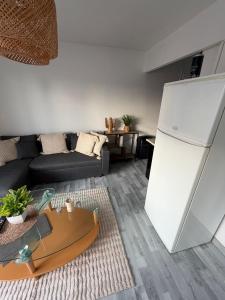a living room with a white refrigerator and a couch at DaxLodge T2 Sotf in Dax