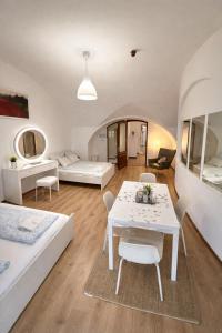 a living room with two beds and a table and chairs at Panzió Apartments in Budapest +30 photos