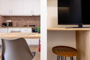 a kitchen with a desk with a television and a chair at Enalis Studios & Apartments in Karfas
