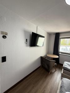 a living room with a tv on a wall at GARLAND Rooms in Bremen