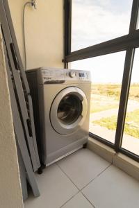 a washing machine in a room with a window at Blue Waves 2 Bedrooms with Pool in Bouznika