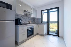 a kitchen with white appliances and a large window at Blue Waves 2 Bedrooms with Pool in Bouznika