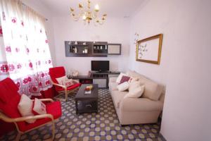 a living room with a couch and red chairs at Casa Lepanto in Tarifa