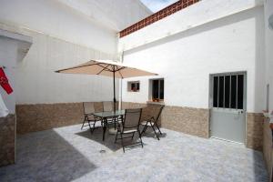 a patio with a table and chairs and an umbrella at Casa Lepanto in Tarifa