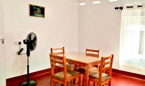 a dining room with a table and chairs and a fan at Samson & Ruby Villa in Weligama