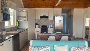a kitchen with a table and a dining room at Binks at Sea in Witsand +20 photos