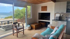 a living room with a couch and a view of the ocean at Binks at Sea in Witsand