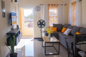 a living room with a couch and a table at Colbeck sunshine oasis in Old Harbour
