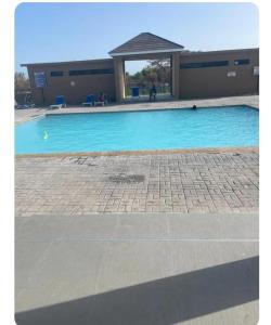 a swimming pool with a gazebo next to a building at Colbeck sunshine oasis in Old Harbour