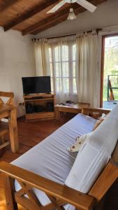 a bedroom with two beds and a flat screen tv at Cabaña La Mechita con jacuzzi privado in Estación Delta