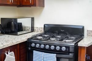 a stove top oven sitting in a kitchen next to a microwave at Colbeck sunshine oasis in Old Harbour