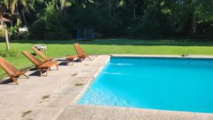 a group of chairs sitting next to a swimming pool at Cabaña La Mechita con jacuzzi privado in Estación Delta +16 photos