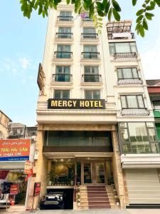 a white building with a mercy hotel sign on it at Mercy Hotel in Hanoi