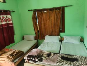 two beds in a room with green walls at Kedar Kunj in Phata +12 photos