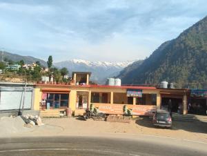 a building with a car parked in front of it at Kedar Kunj in Phata