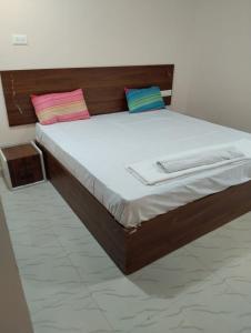 a bed with two pillows on it in a room at I Rose Guest House By Olive in Talaulim