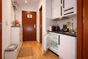 a small kitchen with white cabinets and a wooden floor at Comfortable Apartment on Elbe River in Dresden