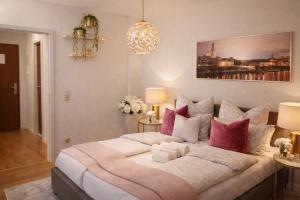 a bedroom with a large bed with pink and white pillows at Comfortable Apartment on Elbe River in Dresden