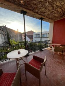 a patio with a table and chairs on a balcony at Le Domino Chambres d'Hôtes et Restaurant in Draguignan