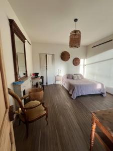 a bedroom with a bed and a chair and a table at Le Domino Chambres d'Hôtes et Restaurant in Draguignan +2 photos