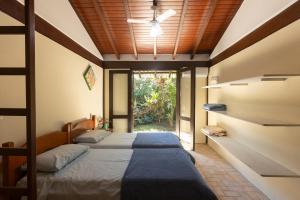 two beds in a room with a window at Casa Jataí Guest House in Barra do Sahy +59 photos