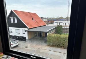a view of a house with a red roof from a window at Rum i villa Burlöv in Arlöv