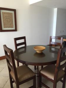 una mesa de comedor con sillas y un tazón. en Bay View Grand Residencial 602 Sur, en Ixtapa