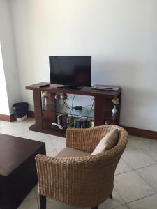 a living room with a chair and a television at Bay View Grand Residencial 602 Sur in Ixtapa