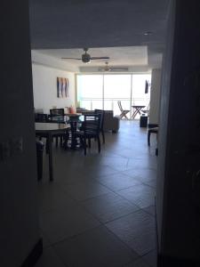 a living room with tables and chairs and a large window at Bay View Grand Residencial 602 Sur in Ixtapa