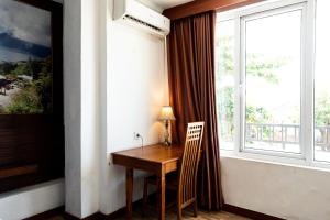 a room with a wooden table and a window at Nusa Dua Moon Hotel in Nusa Dua