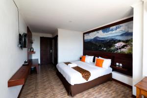 a bedroom with a bed with a large painting on the wall at Nusa Dua Moon Hotel in Nusa Dua +23 photos