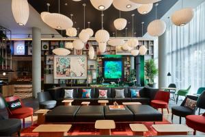 a lobby with a couch and chairs and lights at citizenM Seattle South Lake in Seattle