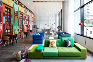 a green couch in the middle of a room at citizenM Seattle South Lake in Seattle