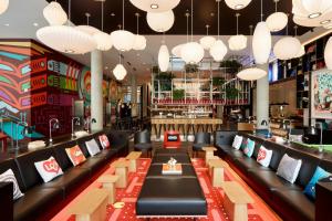 a restaurant with couches and tables and lights at citizenM Seattle South Lake in Seattle