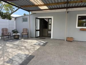 a patio with two chairs and an open door at StayComfy on Jasmin in Oakdale