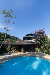 a swimming pool in front of a house at Casa Jataí Guest House in Barra do Sahy