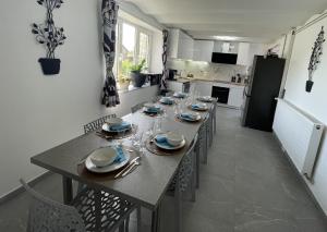 a dining room with a long table with plates and wine glasses at Gite Au Fil du Temps in Walcourt