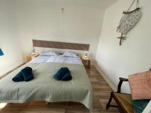 a bedroom with a bed with blue pillows on it at Gite Au Fil du Temps in Walcourt