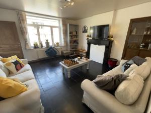 a living room with two white couches and a chess board at Gite Au Fil du Temps in Walcourt