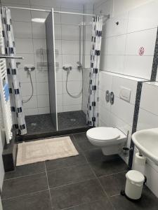 a bathroom with a shower and a toilet and a sink at GARLAND Rooms in Bremen +24 photos