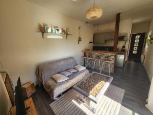 a living room with a couch and a kitchen at Cœur de Toucy in Toucy