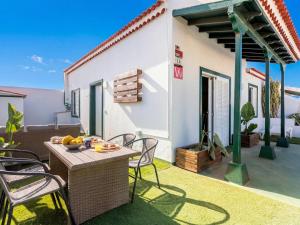 a patio with a table and chairs in front of a house at Vivienda del mar in Arico