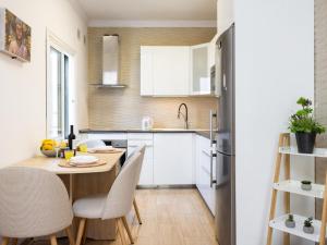 a small kitchen with a wooden table and chairs at Vivienda del mar in Arico +14 photos
